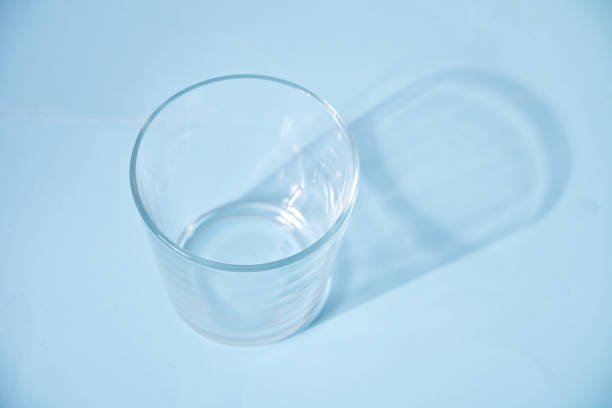 istock Empty transparent glass on the blue background. 1216802666