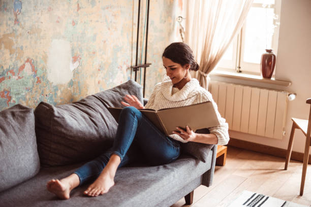 istock woman at home lying down reading a book during the outbreak 1216804102