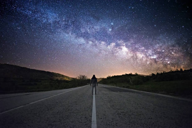 istock Milky Way. Night sky and silhouette of a standing man 1216806424