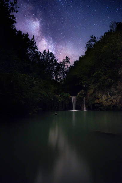 istock Milky Way arch above a flowing Waterfall in the mountain 1216806455