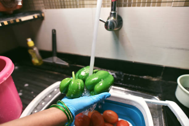 istock Cropped hands wearing protective gloves disinfecting groceries 1216807162