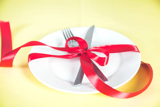 istock plate with spoon, knife and fork tied with red ribbon 1216807747