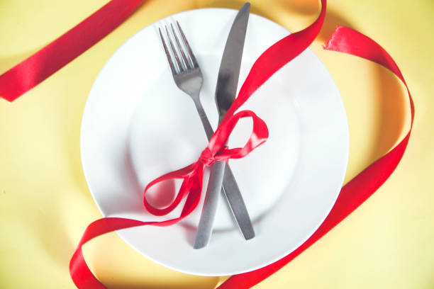 istock plate with spoon, knife and fork tied with red ribbon 1216807761