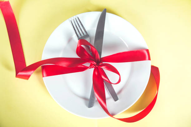 istock plate with spoon, knife and fork tied with red ribbon 1216807779