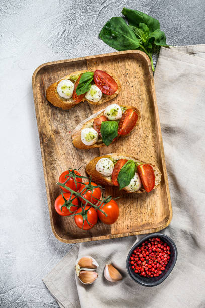 istock sandwiches with tomatoes, mozzarella cheese and basil. italian appetizer, antipasto. gray background. top view 1216808193