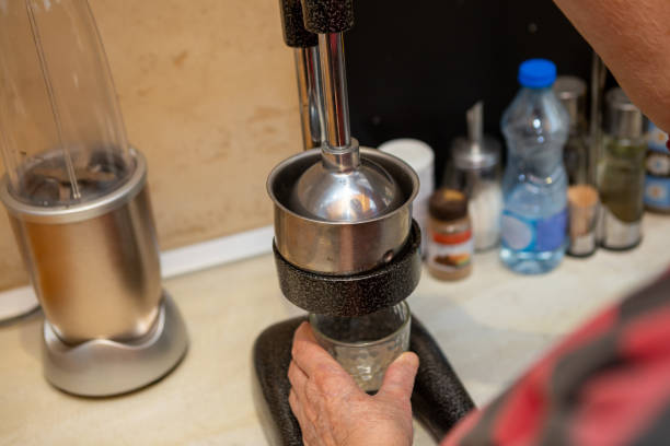 istock Senior woman's hand touching squeezed fruit into a glass in the kitchen. 1216810798