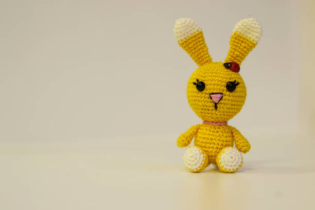 istock Amigurumi yellow hare sitting on a white background. Needlework concept. 1216813949