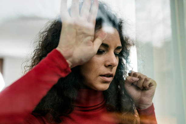 istock Women in quarantine against window glass 1216815770