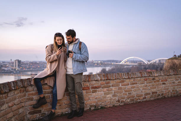 istock Adventurous couple surfing the net on mobile phone while taking a break from cityseeight 1216816391