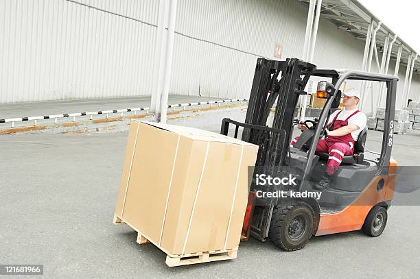 Autista Operaio Di Magazzino Con Carrelli Elevatori - Fotografie stock e altre immagini di Carrello elevatore a forca