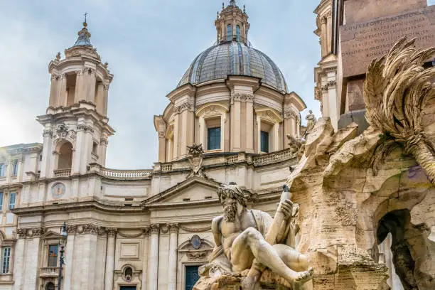Rome, Italy. Sant Agnesse in Agone baroque Church in Piazza Navona Square with Fontana dei Quattro Fiumi (Fountain of Four Rivers) monument. Vintage Italian/ Roman/ European art and architecture.