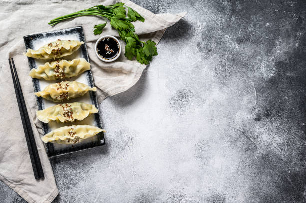 istock Steam Korean dumplings on a ceramic plate. Gray background. Top view. Space for text. 1216820838