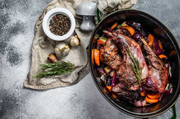 gebratene hasenbeine in der pfanne mit knoblauchzwiebel und rosmarin. ansicht von oben. bio-fleisch. platz für text - hase wildfleisch stock-fotos und bilder