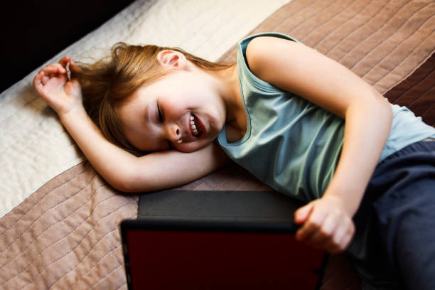 istock girl with tablet laying on the bed 1216822768