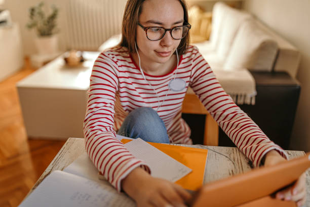 istock Girl using digital tablet and headphones for online distance learning 1216823904