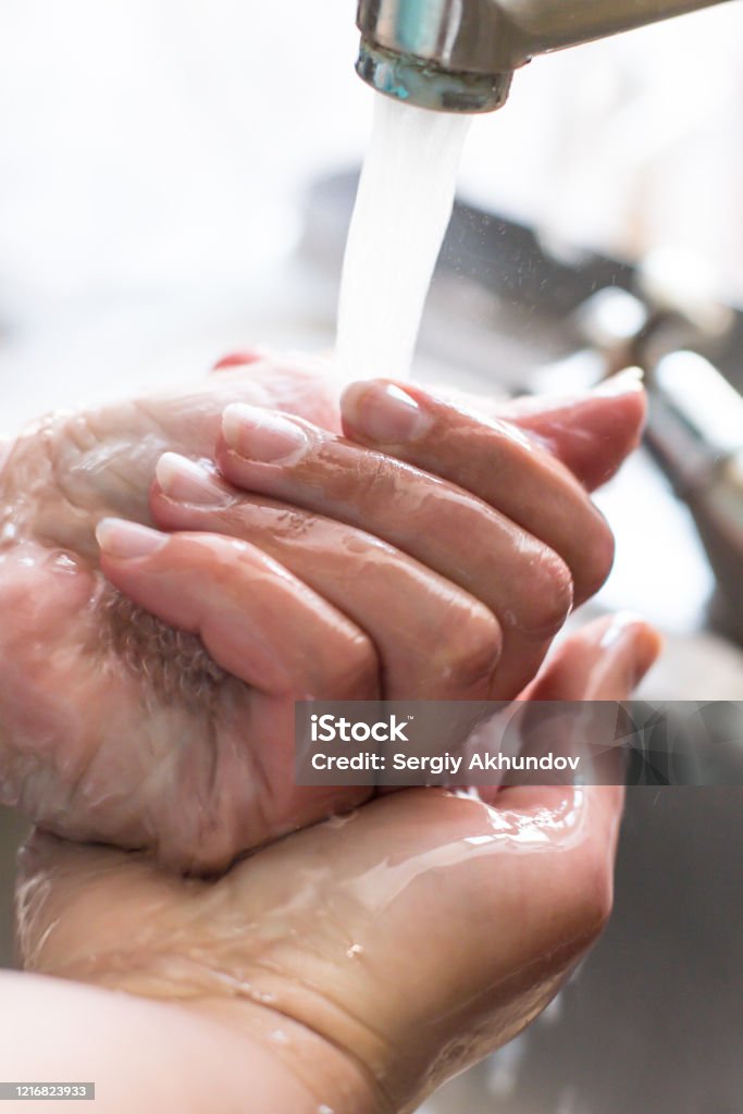 Wash hands with soap for coronavirus. Female hands with manicure in a kitchen sink Girl washes hands under the tap close-up. Wash your hands often to prevent virus infection. Bacterium Stock Photo