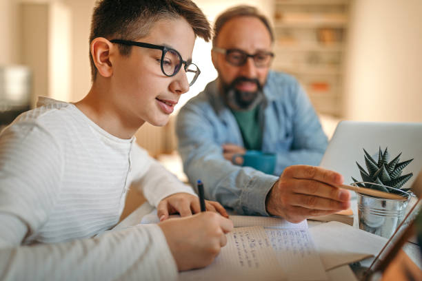 istock Father helping son with homework at home office 1216824311