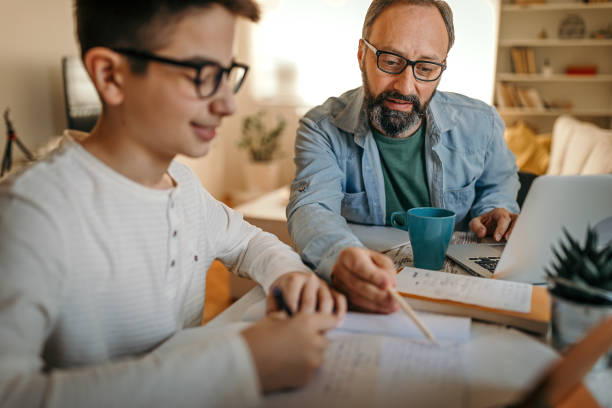 istock Father helping son with homework at home office 1216824552