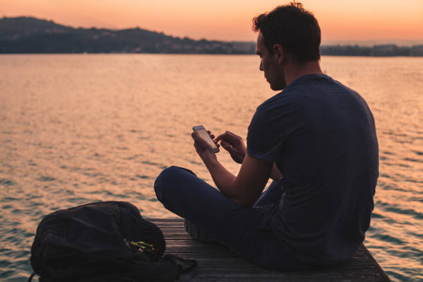 istock man using mobile internet on smartphone outside near lake 1216828063