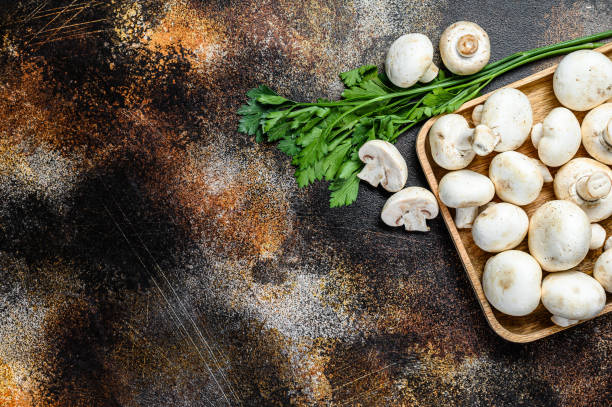 istock mushroom champignon in a bamboo bowl. Dark background. Top view.  Space for text 1216828868