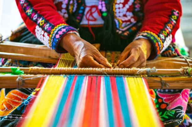 Indigenous Textile Weaving, Cusco, Peru Peruvian indigenous Quechua woman weaving a textile with the traditional techniques in Cusco, Peru. cultural craft stock pictures, royalty-free photos & images