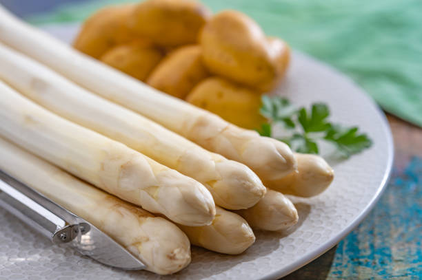 istock Ingredients for spring vegetarian dinner, high quality Dutch white asparagus, washed and peeled on board, ready to cookand and young potatoes 1216831005