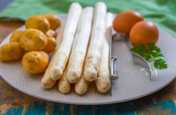 Ingredients for spring vegetarian dinner, high quality Dutch white asparagus, washed and peeled on board, ready to cook