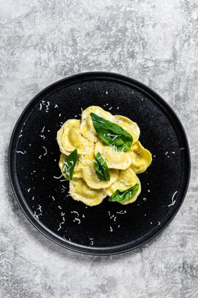 istock Italian ravioli pasta with cheese and Basil. Gray background. Top view 1216831945
