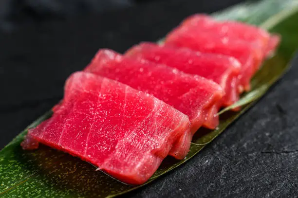 sashimi tuna on a stone Board. Black background. Top view. Close up.