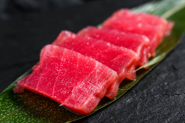 bir taş tahta üzerinde sashimi ton balığı. siyah arka plan. üst te. yakın çekim - sashimi stok fotoğraflar ve resimler