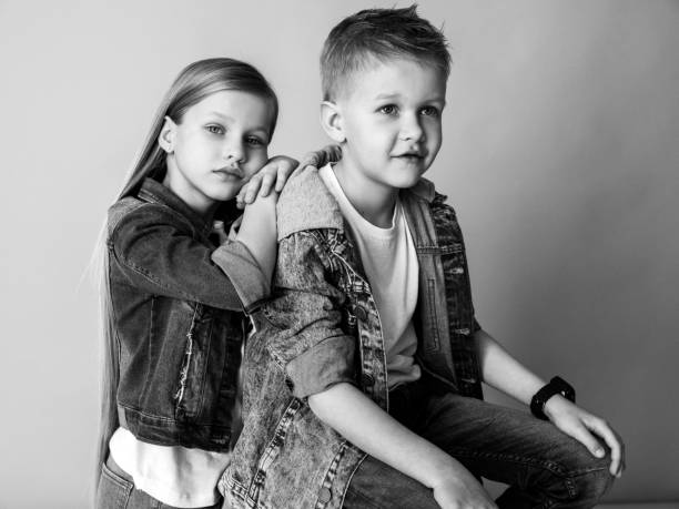 A brother and sister share a laugh in b&w.