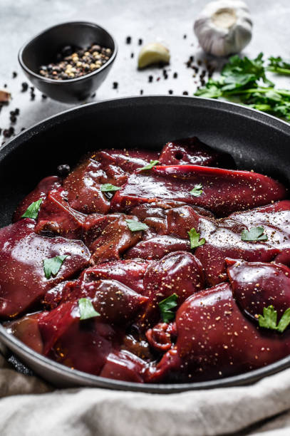istock Raw duck liver in a frying pan. Gray background. Top view 1216835612