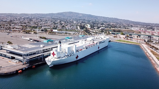 Los Angeles CA: 3/29/2020 - The USNS Mercy (T-AH-19) at the port of Los Angeles in San Pedro CA. USNS Mercy (T-AH-19) is the lead ship of her class of hospital ships in non-commissioned service with the United States Navy. Her sister ship is USNS Comfort (T-AH-20). She is the third US Navy ship to be named for the virtue mercy. In accordance with the Geneva Conventions, Mercy and her crew do not carry any offensive weapons, though defensive weapons are available. Attacking Mercy is a war crime.