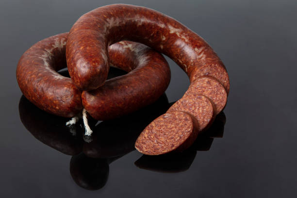 Turkish sausage kangal sucuk. Traditional garlic-flavored sausage called sucuk isolated on black background. Turkish sausage kangal sucuk. Sujuk (sucuk), a dry spicy sausage  isolated on black background. turkish sausage stock pictures, royalty-free photos & images