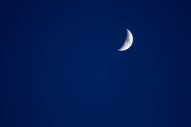 istock Crescent moon in the blue sky satellite crater copyspace 1216839468