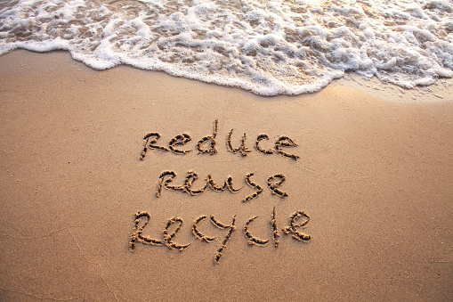 reduce reuse recycle concept drawn on sand, sustainability