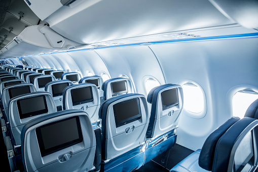 Interior of an empty airplane. View from the back of the plane. Nobody on the plane. Abstract air travel photo.