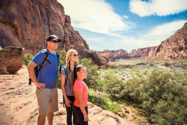Young family hiking in beautiful Red Rock Canyon in Southwest USA Attractive young family looking out at a beautiful scenic view in a red rock canyon in the Southwest United States. snow canyon state park stock pictures, royalty-free photos & images