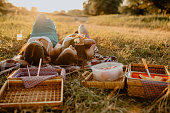 Two women lying down on picnic blanket on a sunny day in nature