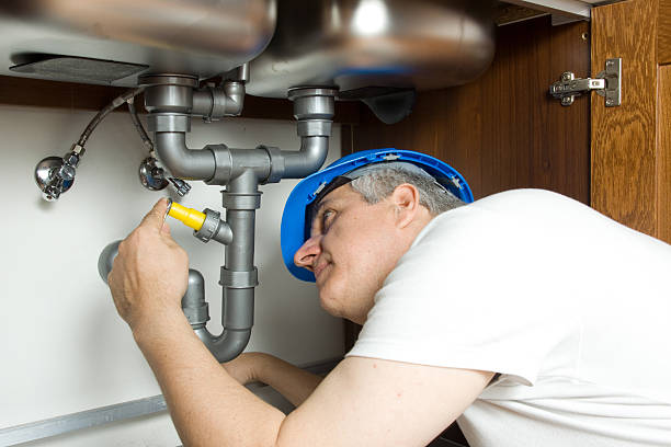 istock Plumber fixing sink pipes under cabinet 121684957