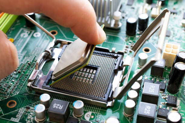 istock Engineer carefully installs a microprocessor CPU in the slot of the motherboard. 1216850917