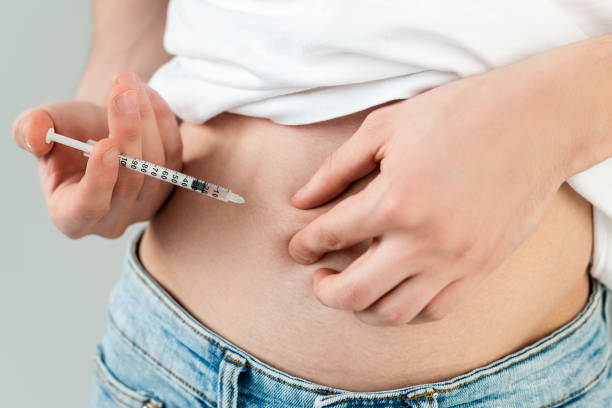 istock Cropped view of man doing hormonal injection in belly isolated on grey 1216852179