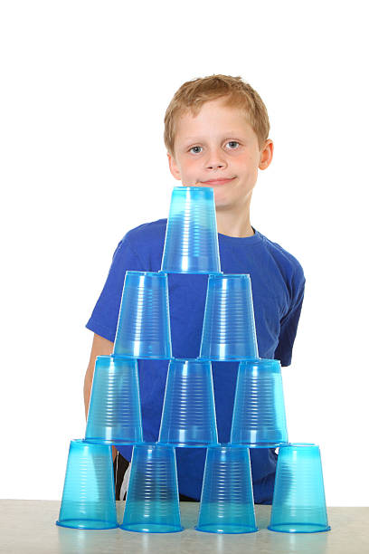 junge mit pyramide körbchen - cup child geometric shape stacking stock-fotos und bilder