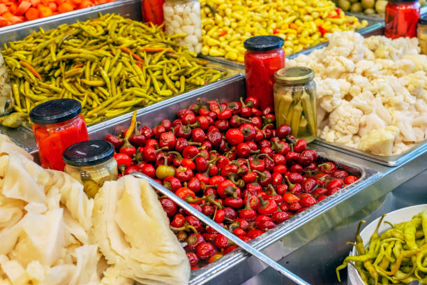 Traditional Turkish pickles of various fruits and vegetables sold in big glass cans in market, Izmir, Turkey.