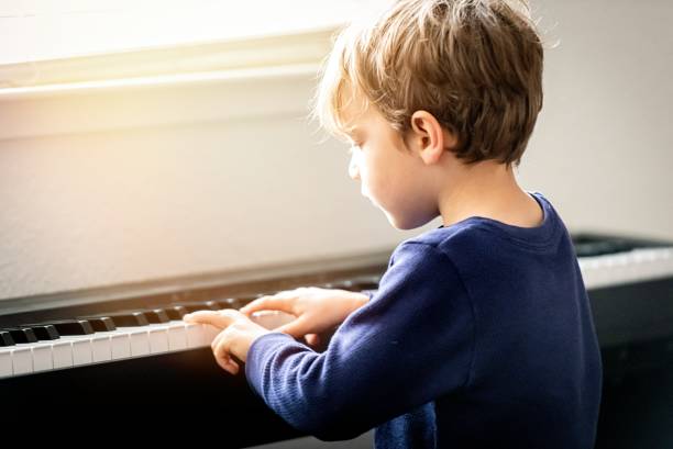 Little boy learning how to play piano during the Covid-19 lockdown