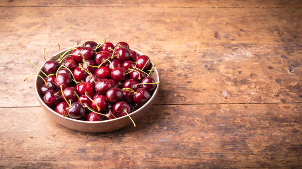 istock Ripe cherries on a wooden table - panoramic background with copy space 1216857303
