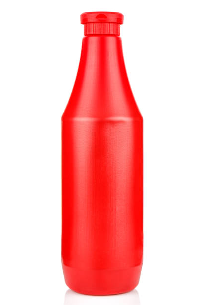 istock Red plastic bottle of tomato ketchup isolated on white background with reflection on glossy surface 1216857817