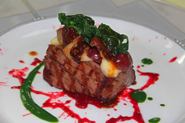 istock grilled beef steak with cherry sauce, mashed potato, spinach and foie gras in a white plate 1216861772