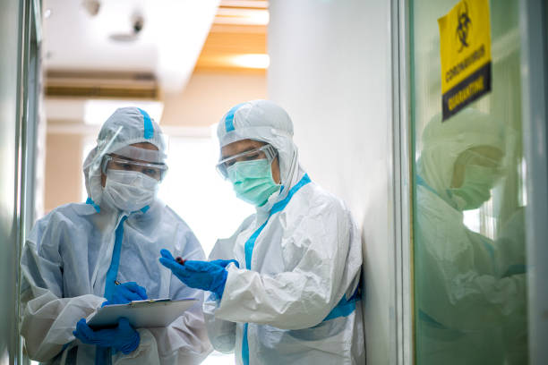 asian doctor checking coronavirus or covid-19 infected patient in quarantine room - protective suit fotos imagens e fotografias de stock