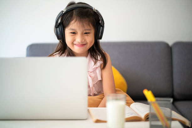 chica asiática usando computadora portátil para el estudio en línea durante la educación en casa en casa - educación en el hogar fotografías e imágenes de stock